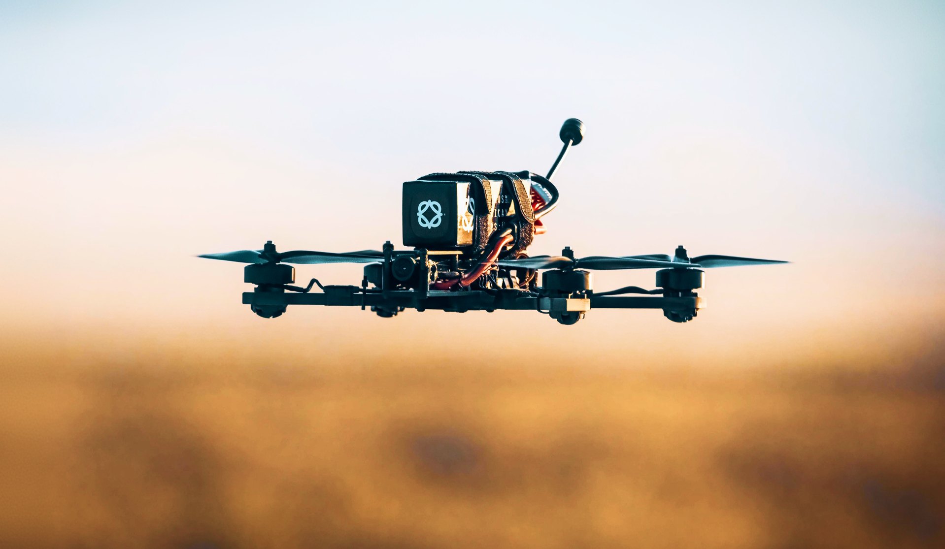 Matrix 7 hovering at low altitude over open ground at dusk